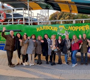 Professor Volker Straub with some members of his team standing in front of a green boat with the words "Harbour Hopper" printed on the side.