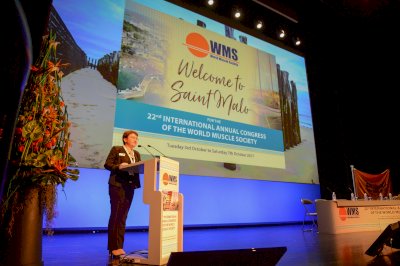 Dr Bonne stands on stage at a WMS Congress