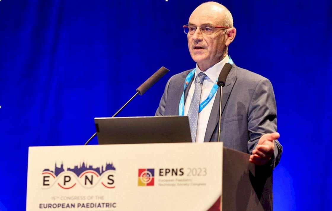 Image shows Professor Francesco Muntoni presenting at EPNS 2023. he is standing behind a lectern and gesturing with his left hand.