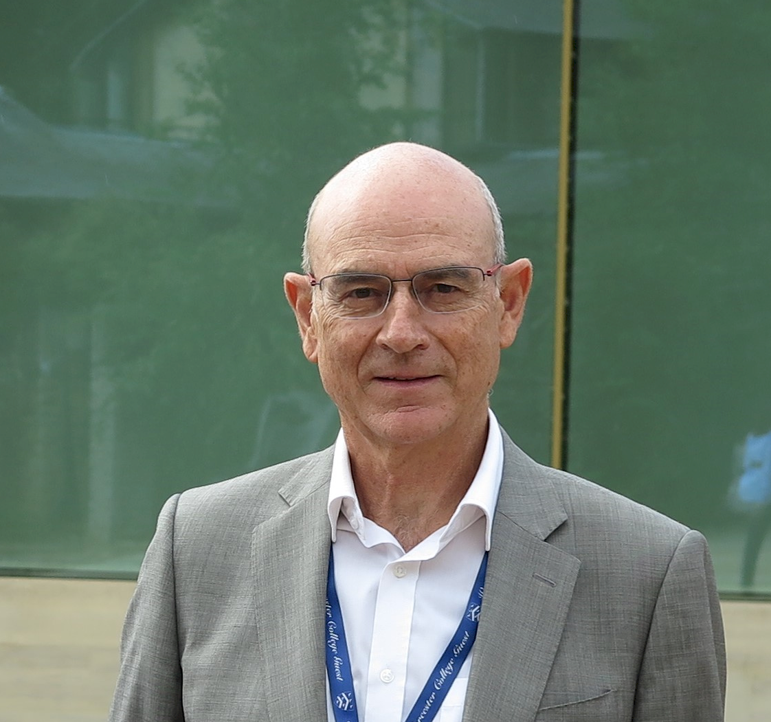 Image is a head shot of Professor Francesco Muntoni. He is outdoors and wearing a white shirt, open at the collar, with a grey blazer. He is also wearing a blue lanyard